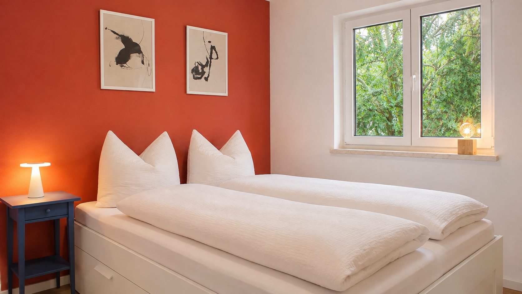 Schlafzimmer mit Doppelbett und terracottafarbener Wand